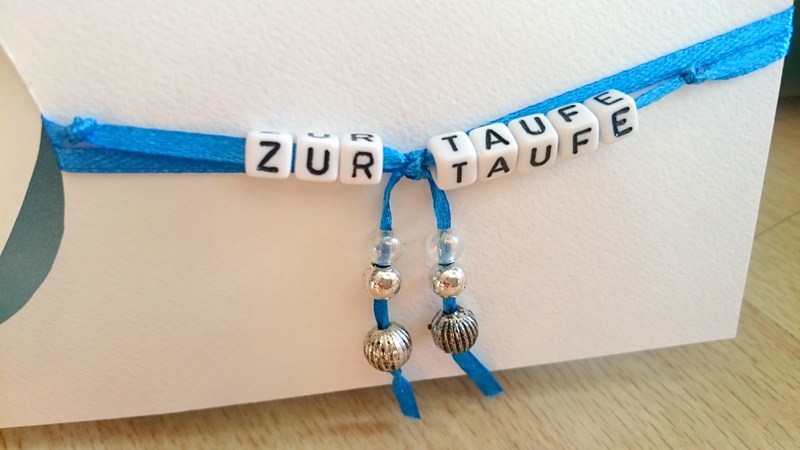 Perlen mit dem Schriftzug "zur Taufe"